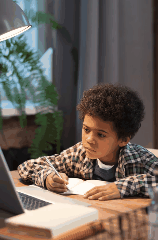 A student taking notes while following an online lesson